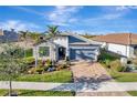 One-story house with gray garage door and landscaped yard, aerial view at 13005 Rinella St, Venice, FL 34293