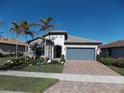 One-story house with stone accents, gray garage door, and palm trees at 13005 Rinella St, Venice, FL 34293