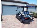 Rear view of blue golf cart with white and blue striped seats at 13005 Rinella St, Venice, FL 34293