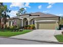 Tan one-story house with a two-car garage and lush landscaping at 13122 50Th E Ct, Parrish, FL 34219