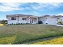 Single-story home with a two-car garage and landscaped lawn at 14065 Paris Ln, Port Charlotte, FL 33981