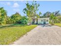 Light green house with spacious lawn, and a gravel driveway at 2910 49Th St, Sarasota, FL 34234