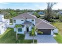 Modern two-story house with a gray roof and paved driveway; canal view at 901 30Th E Ct, Bradenton, FL 34208