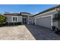 Single-story home with gray exterior, paver driveway, and garage at 9908 Carnoustie Pl, Bradenton, FL 34211