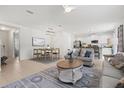 Bright living room boasts an open floor plan with a dining area and modern furnishings for a seamless living experience at 12939 Seasong Ter, Bradenton, FL 34211