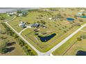 An aerial view displays a property with a home, barn, pond, surrounded by a white fence on a large lot at 25205 67Th E Ave, Myakka City, FL 34251