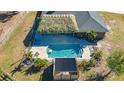 A high angle shot captures a private pool with a tiki hut, a covered pergola, and brick patio at 25205 67Th E Ave, Myakka City, FL 34251