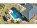 Aerial view of a private pool with a tiki hut, a covered pergola, and brick patio at 25205 67Th E Ave, Myakka City, FL 34251