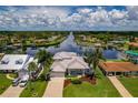 Stunning aerial view of single-Gathering home, featuring a metal roof, landscaping, and waterfront location at 4440 Tatum St, Port Charlotte, FL 33948