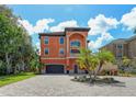 Inviting three-story home with Mediterranean architecture and a paved driveway at 2412 Bay Dr W Ave, Bradenton, FL 34207