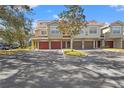 Front view of townhome with red garage doors and landscaping at 4990 Baraldi Cir # 101, Sarasota, FL 34235