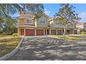 Row of townhomes with red garage doors and mature trees at 4990 Baraldi Cir # 101, Sarasota, FL 34235