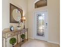 Elegant entryway with a decorative console table and stained glass door at 6870 Willowshire Way, Bradenton, FL 34212