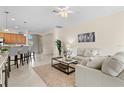 Cozy living room with neutral decor, a ceiling fan, and an arched entryway to the kitchen at 6870 Willowshire Way, Bradenton, FL 34212