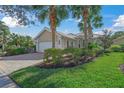 Tan house with white garage door and palm trees in the front yard at 5762 Benevento Dr, Sarasota, FL 34238