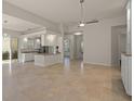 Open floor plan with tile floors, kitchen island, and a ceiling fan at 5762 Benevento Dr, Sarasota, FL 34238