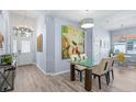 Bright dining area with glass table, beige chairs, and hardwood floors at 5200 Highbury Cir, Sarasota, FL 34238