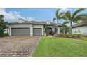 Two-story house with gray siding, two-car garage, and landscaping at 6839 Chester Trl, Bradenton, FL 34202