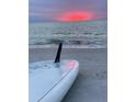 Beautiful beach with a surfboard on the sand at sunset at 745 Bruce Ave, Clearwater Beach, FL 33767