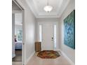 Bright entryway with tile flooring, a wooden side table, and large artwork at 5397 Bartolomeo St, Sarasota, FL 34238