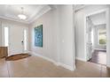 Light-filled entryway with tile floor, white door, and modern wall art at 5397 Bartolomeo St, Sarasota, FL 34238