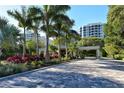 Gated entrance to community with lush landscaping and palm trees at 1211 Gulf Of Mexico Dr # 408, Longboat Key, FL 34228