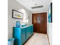Bright and spacious entryway with blue console table and modern art at 1211 Gulf Of Mexico Dr # 408, Longboat Key, FL 34228
