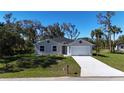 Charming single-story home with a well-manicured lawn and a two-car garage at 1859 Lamont St, North Port, FL 34288