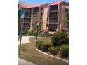 Landscaped grounds of a condo building with a pathway at 3006 Caring Way # 409, Port Charlotte, FL 33952