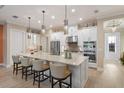 Modern kitchen with stainless steel appliances, large island, pendant lighting and bar stool seating at 4611 Trento Pl, Bradenton, FL 34211