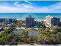 Aerial view of oceanfront condo building with tennis courts at 1211 Gulf Of Mexico Dr # 706, Longboat Key, FL 34228