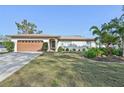 Well-maintained single-story home with a manicured lawn, mature landscaping, and a two-car garage at 151 Adair Ave, Sarasota, FL 34243