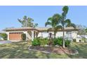 Well-maintained single-story home with a manicured lawn, mature landscaping, and a two-car garage at 151 Adair Ave, Sarasota, FL 34243