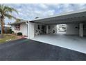 Front view of a light-colored home with carport and patio seating at 1741 Caribbean Cir # 13, Venice, FL 34293