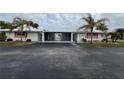 Front view of a light-colored home with carport and palm trees at 1741 Caribbean Cir # 13, Venice, FL 34293