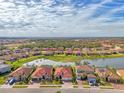 Aerial view of a house in a community by a lake at 20717 Benissimo Dr, Venice, FL 34293