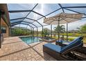 Screened pool and spa with lounge chairs and an umbrella at 20717 Benissimo Dr, Venice, FL 34293