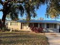 Ranch style home with gray exterior and mature landscaping at 4951 Bell Meade Dr, Sarasota, FL 34232