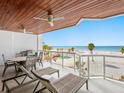 Relaxing covered balcony with outdoor seating area and stunning views of the white sand beach at 1035 Seaside Dr # 305, Sarasota, FL 34242
