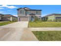 Two-story house with gray siding, teal shutters, and a two-car garage at 4016 86Th E St, Palmetto, FL 34221