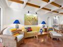 Living room with terracotta floors, yellow couch, and wood beam ceilings at 1080 W Peppertree Ln # 506A, Sarasota, FL 34242