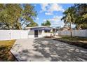 Front view of a white house with a driveway and fenced yard at 2369 Browning St, Sarasota, FL 34237