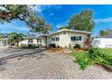 Nice curb appeal! Yellow house with teal door and brick driveway at 2629 Martin St, Sarasota, FL 34237