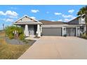 Two-story home with gray exterior, three car garage, and landscaped yard at 11160 Fieldstone Dr, Palmetto, FL 34221