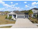 Two-story home with gray exterior, three car garage, and landscaped yard at 11160 Fieldstone Dr, Palmetto, FL 34221