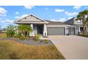 Two-story home with gray exterior, three car garage, and landscaped yard at 11160 Fieldstone Dr, Palmetto, FL 34221