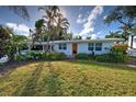 Front view of a renovated home with a vibrant orange door and lush landscaping at 315 Palmetto W Rd, Nokomis, FL 34275