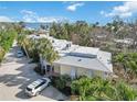 Exterior view of a charming condo building with metal roof and tropical landscaping at 5310 Gulf Of Mexico Dr # 11, Longboat Key, FL 34228