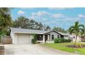 Single-story home with attached garage, mature landscaping, and a palm tree at 6201 34Th W Ave, Bradenton, FL 34209