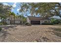 White house with brown roof, stone accents, and a large driveway at 3970 Prairie Dunes Dr, Sarasota, FL 34238